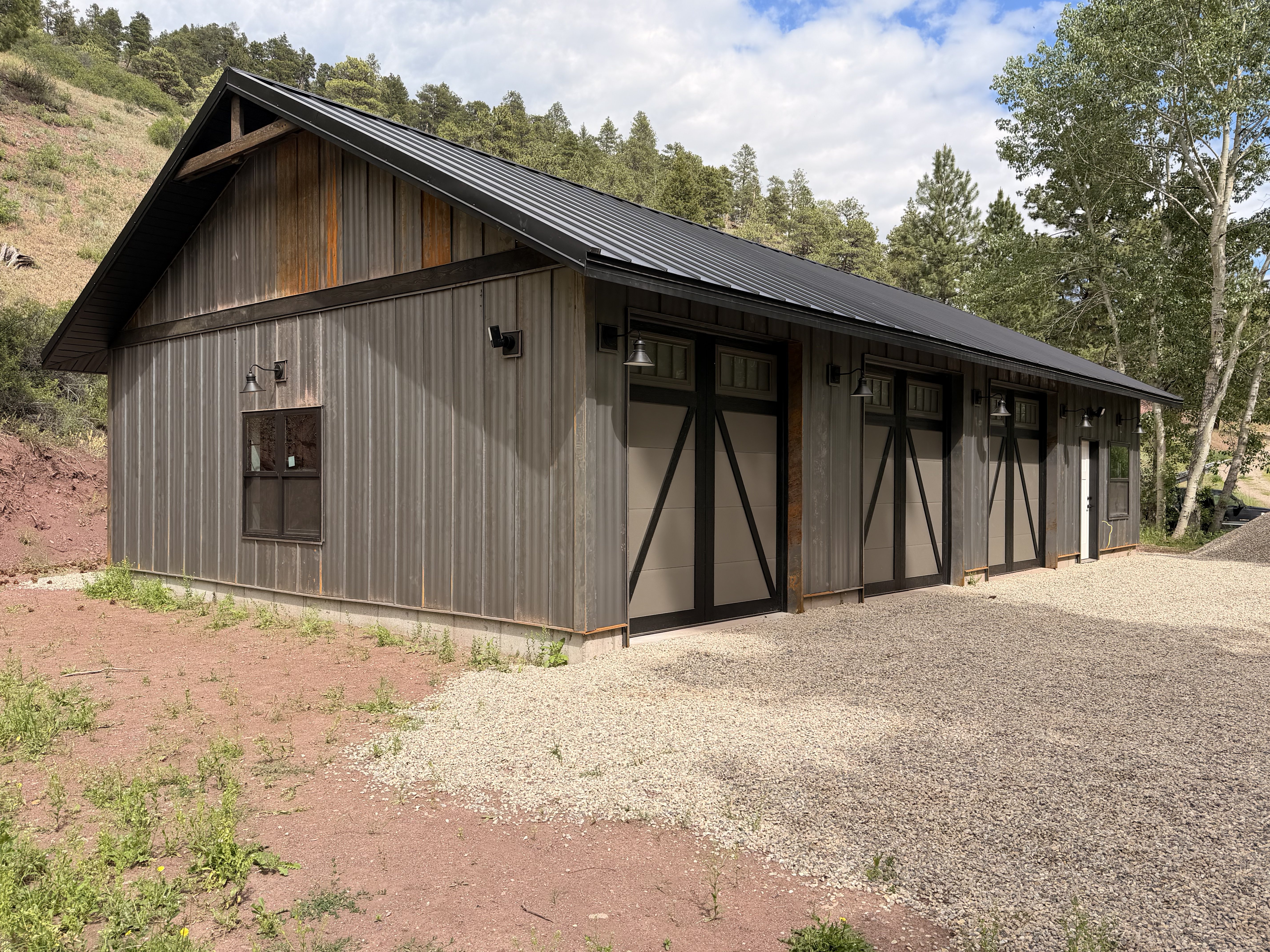 Outbuilding front angle — standing seam metal roof & board and batten siding
